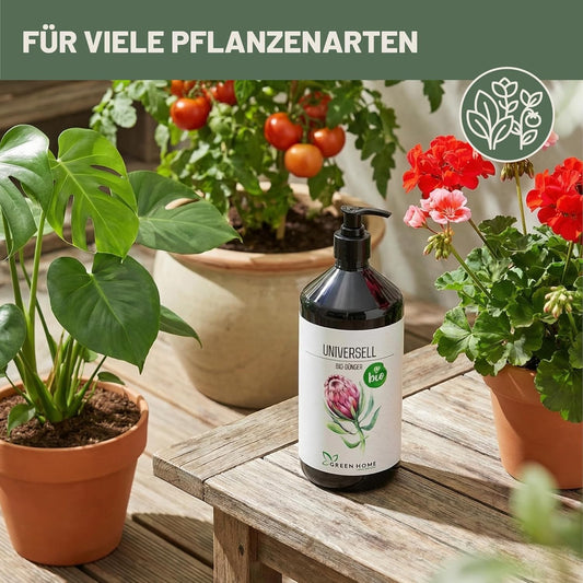 Green Home Bio Dünger Universell steht auf einem Holztisch zwischen verschiedenen Pflanzen wie Monstera, Tomaten und Geranien