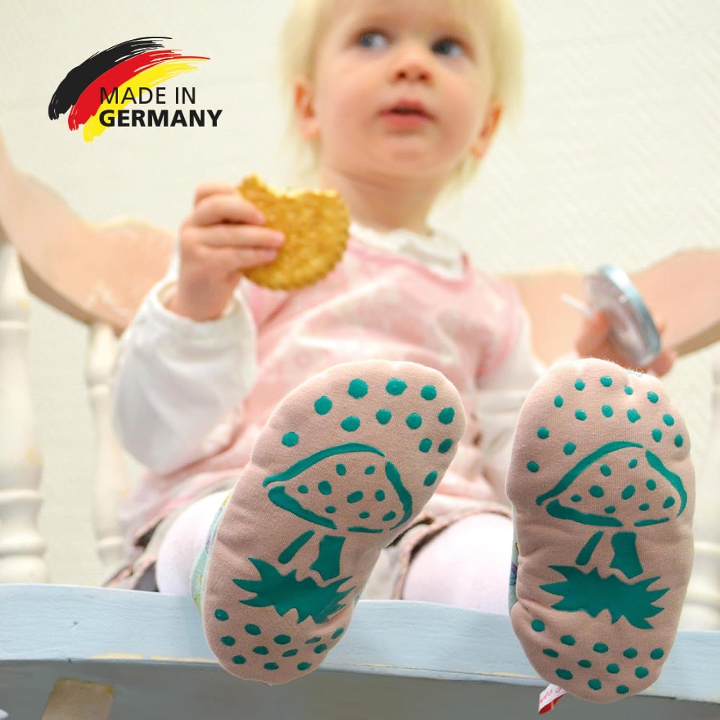 Baby mit Socken mit rutschfester Unterseite und Pilzmotiv, gestaltet mit der LM Kreativ Socken Stopper Textilfarbe, Hinweis auf Made in Germany.