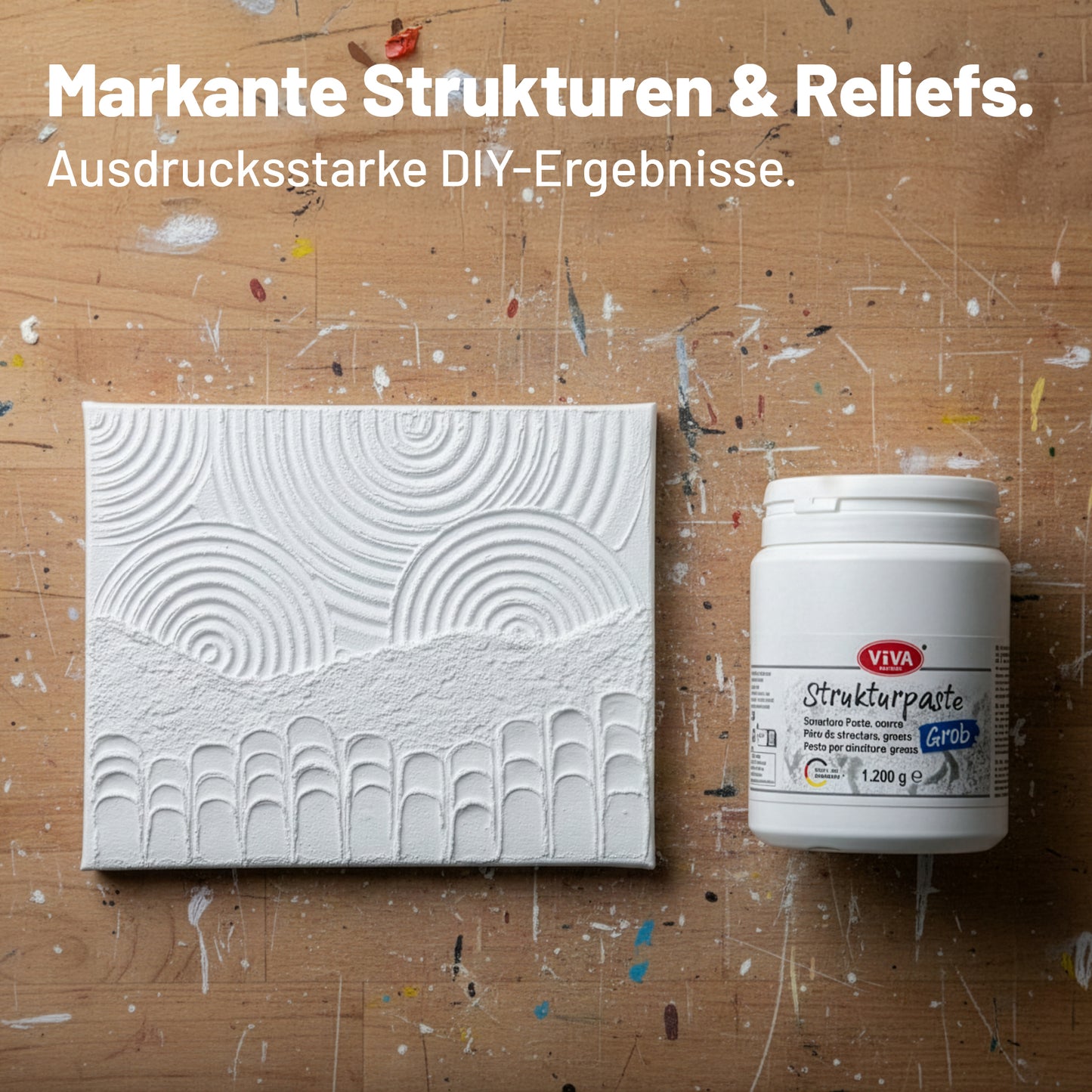 Mit Viva Decor Strukturpaste Grob gestaltete Leinwand mit ausgeprägten Reliefstrukturen neben dem Produktbehälter im Atelier.