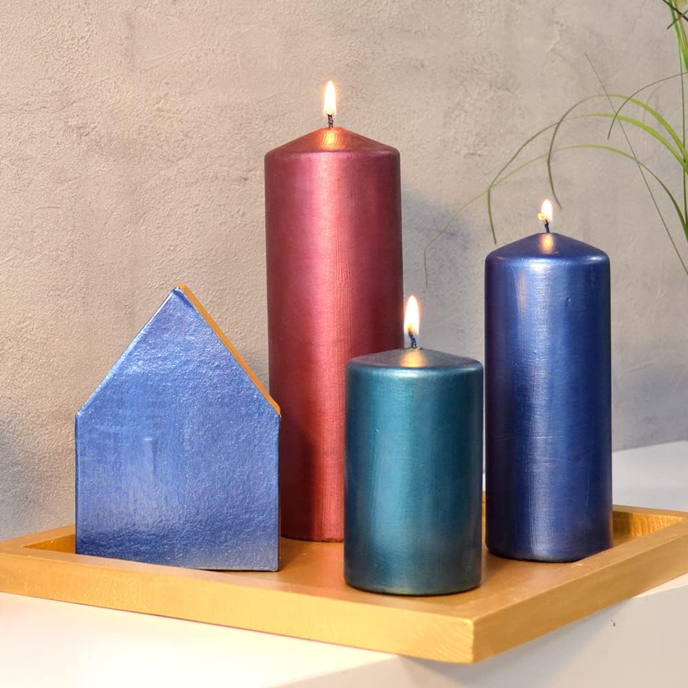 Mit Inka Gold veredelte Kerzen und Holzobjekte in Blau-, Rot- und Petroltönen mit edlem Metallglanz