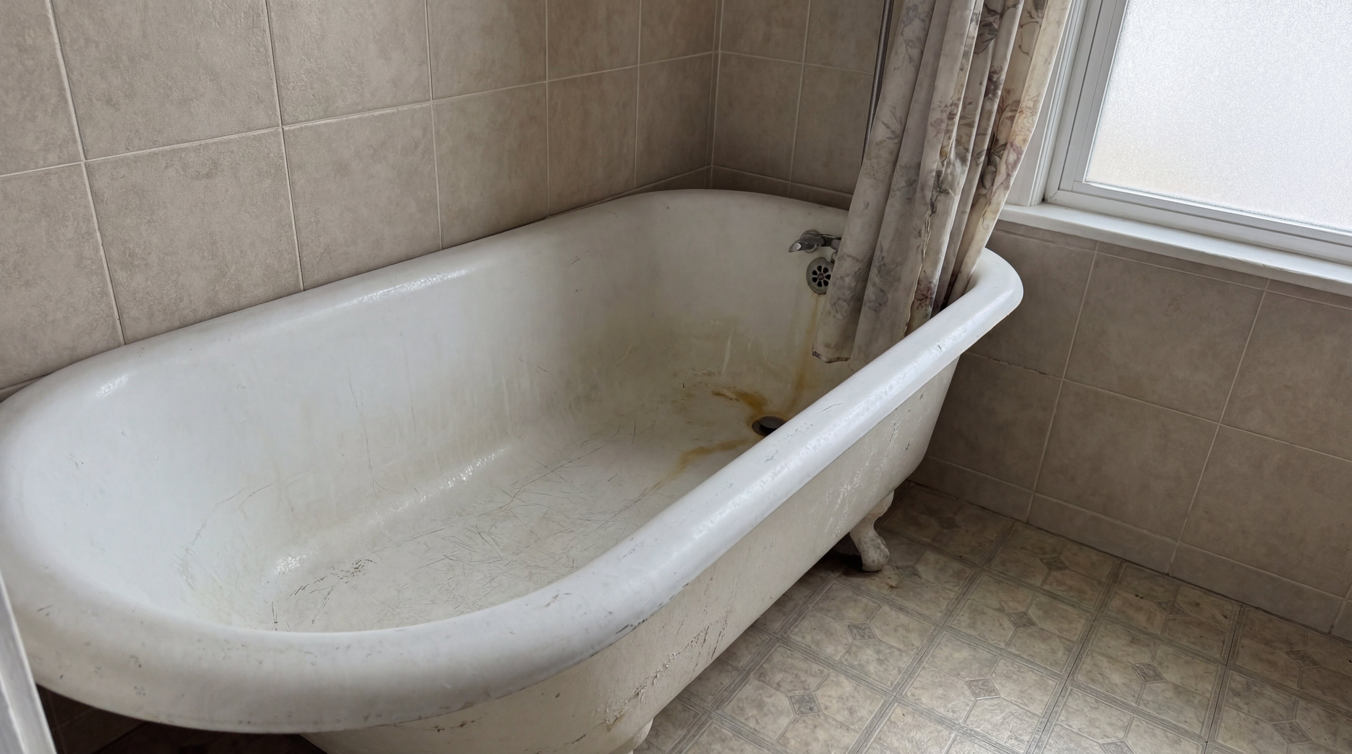 Alte Badewanne mit sichtbaren Abnutzungsspuren und Verschmutzungen