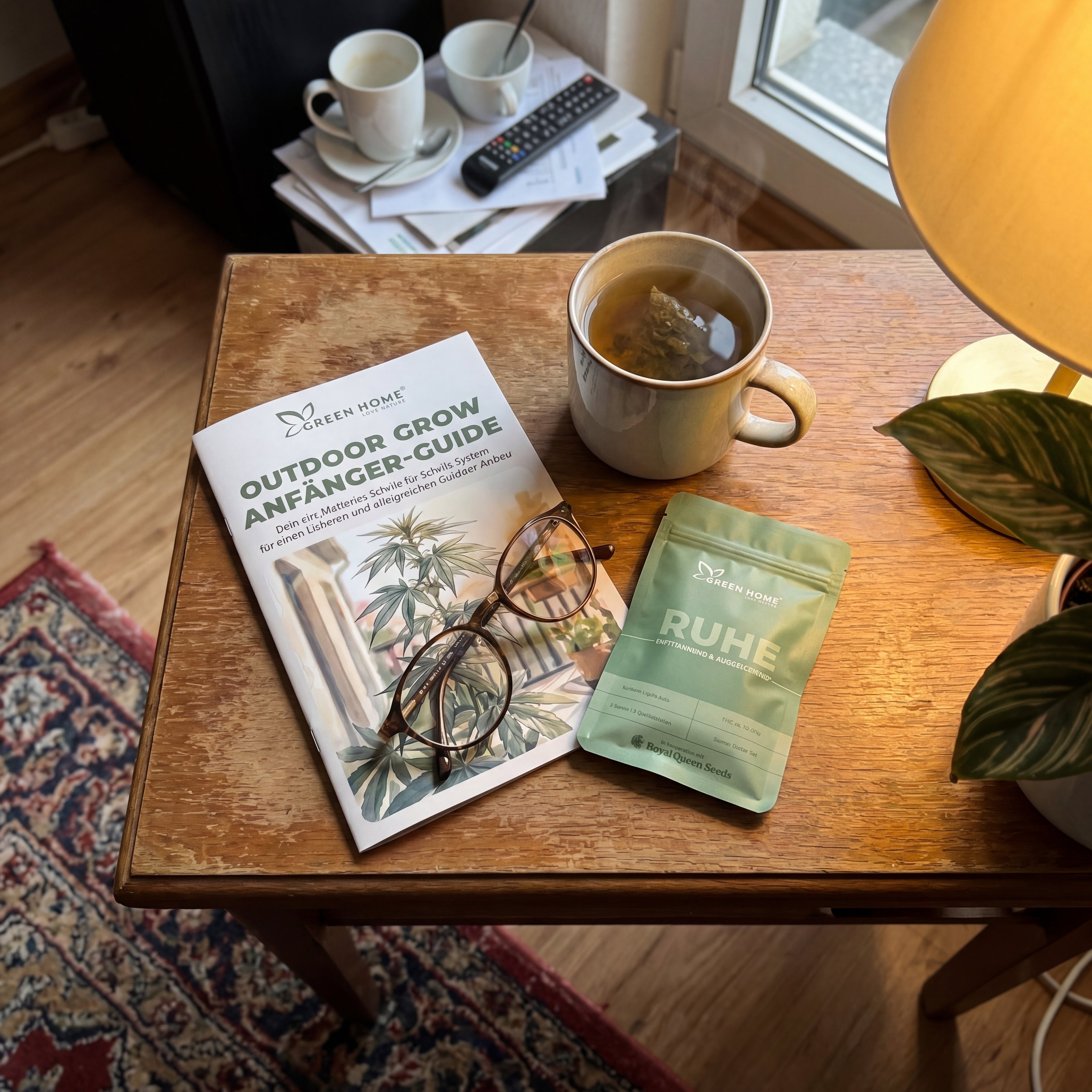 Green Home RUHE Samentüte mit Outdoor Grow Guide und Kräutertee auf Beistelltisch im Nachmittagslicht