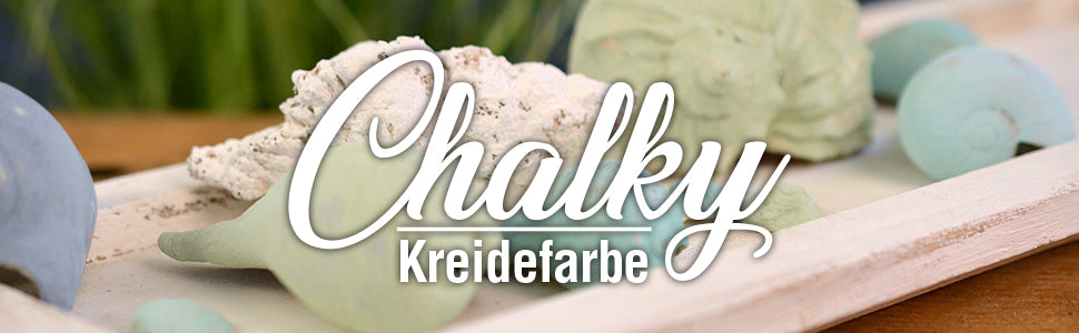 Dekorative Muscheln und Schneckenhäuser in sanften Pastelltönen auf einem Tablett mit Schriftzug Chalky Kreidefarbe als Headerbild.