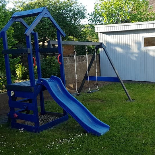 Blau gestrichenes Holzspielgeraet im Garten als Beispiel fuer die Aussenanwendung mit ColourPlus Buntlack 2in1