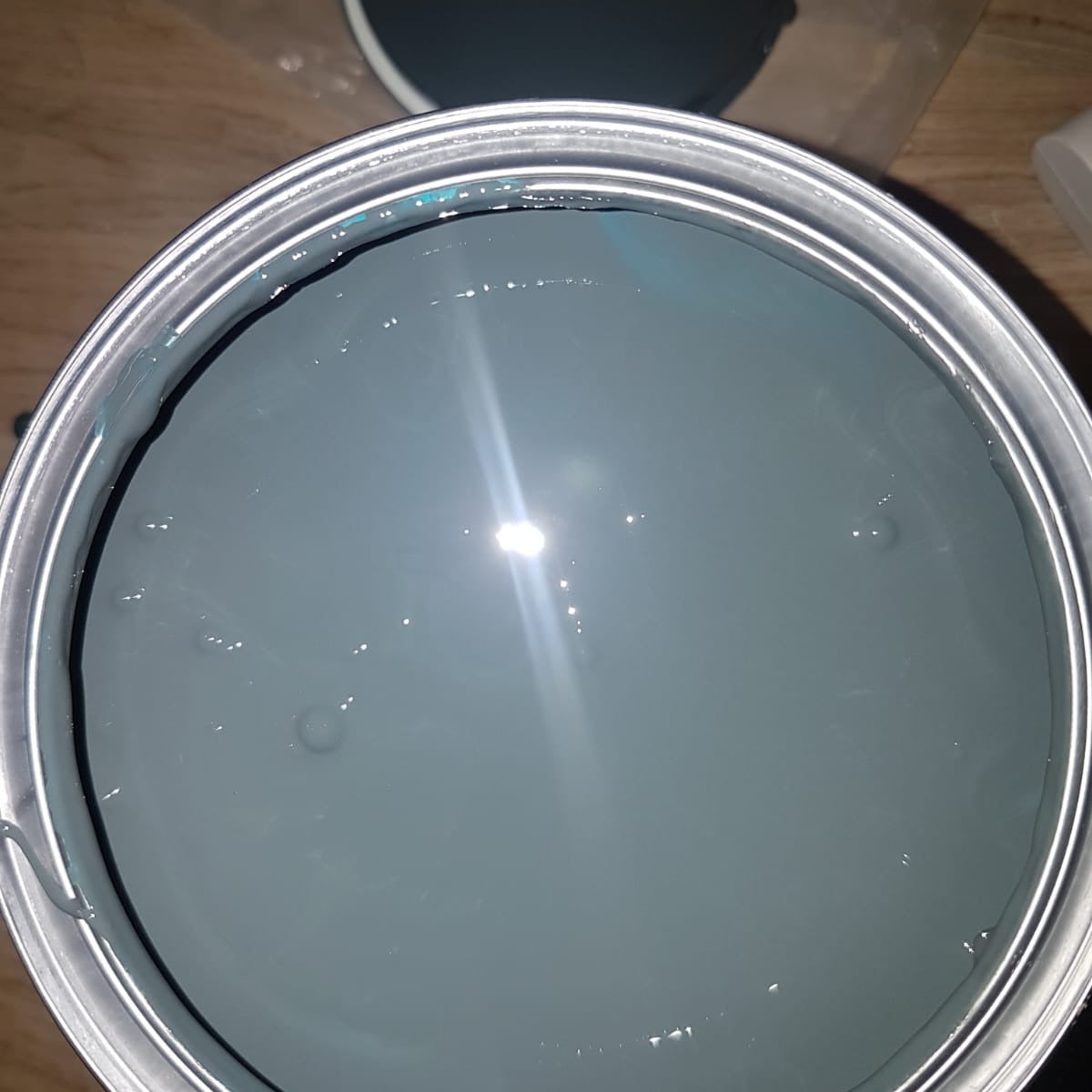 Geöffneter Farbeimer mit ColourPlus Wetterschutzfarbe in Anthrazit als Nahaufnahme der Farboberfläche.