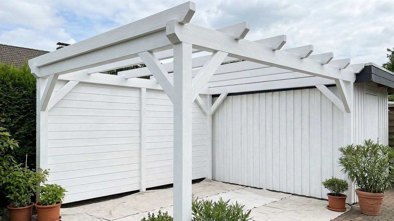 Mit ColourPlus Wetterschutzfarbe in Reinweiß gestrichene Pergola und Sichtschutzwand im Garten.