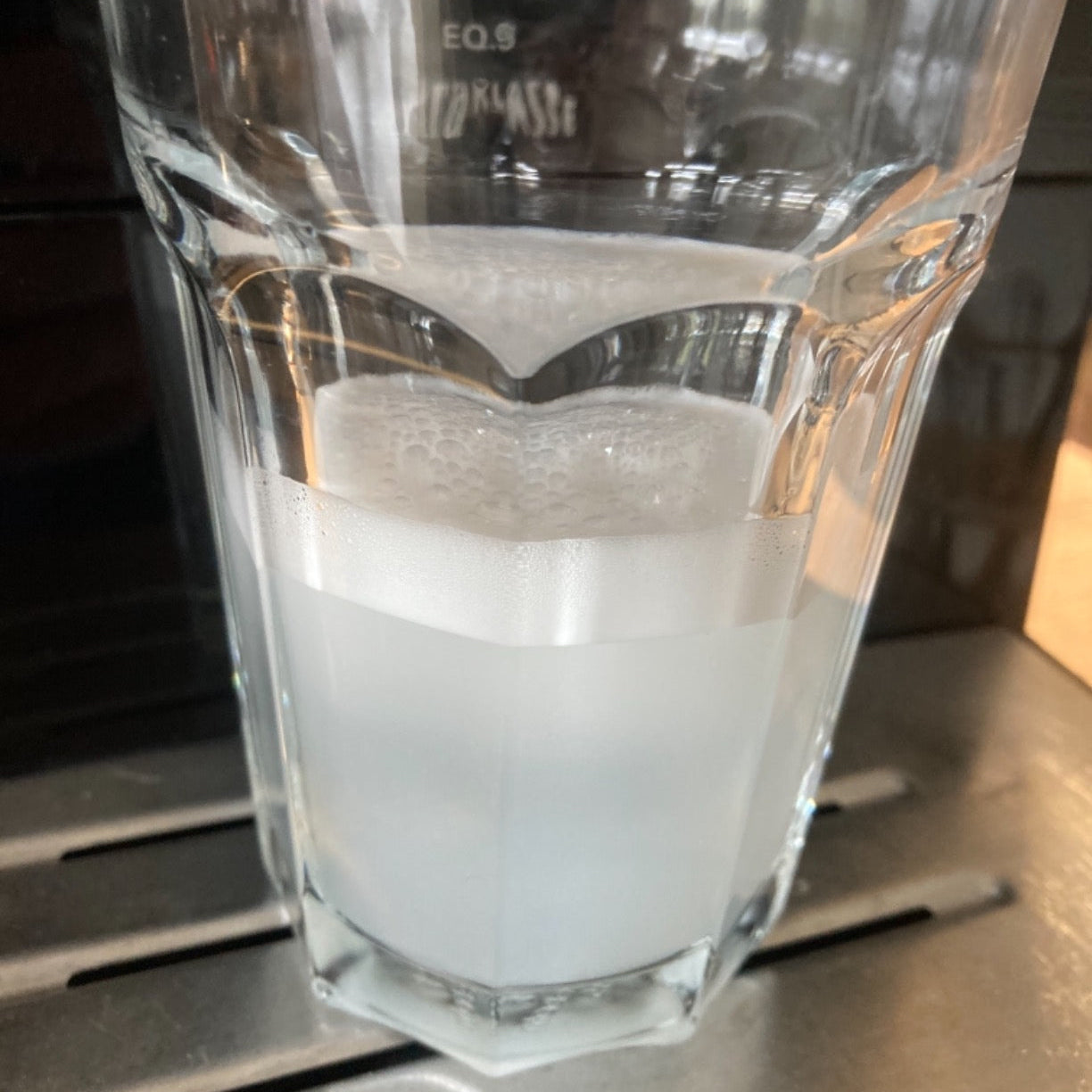 Glas mit verduennter Reinigungslösung des Eco Clean Milchsystemreinigers zur Anwendung im Milchsystem.