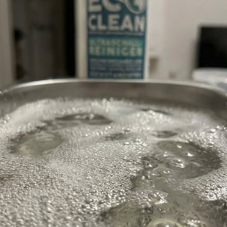Detailaufnahme eines Ultraschallbads mit sichtbarer Schaumbildung waehrend der Reinigung mit Eco Clean Ultraschallreiniger.