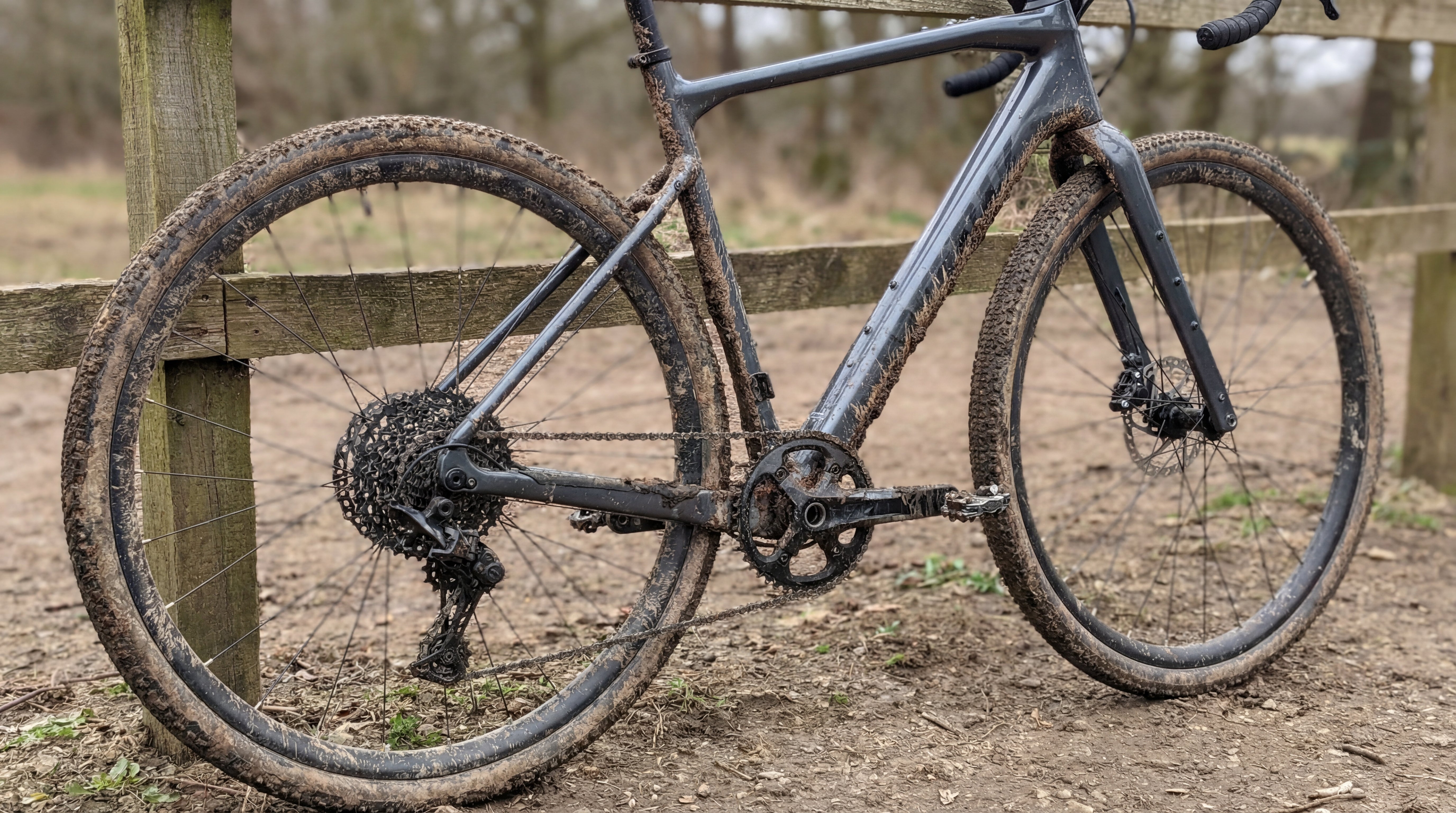 Komplett verschmutztes Gravelbike mit Schlamm an Rahmen, Kassette und Reifen als Vorher-Bild.
