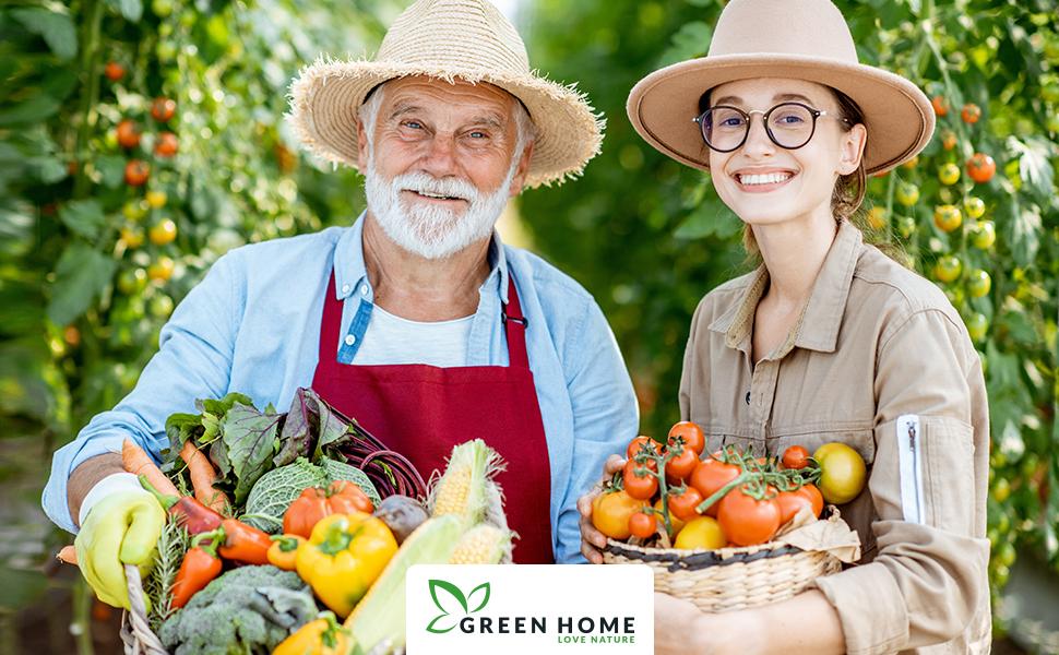 Zwei Gärtner mit gefüllten Erntekörben voller Gemüse im Gewächshaus mit Green Home Logo im Vordergrund.