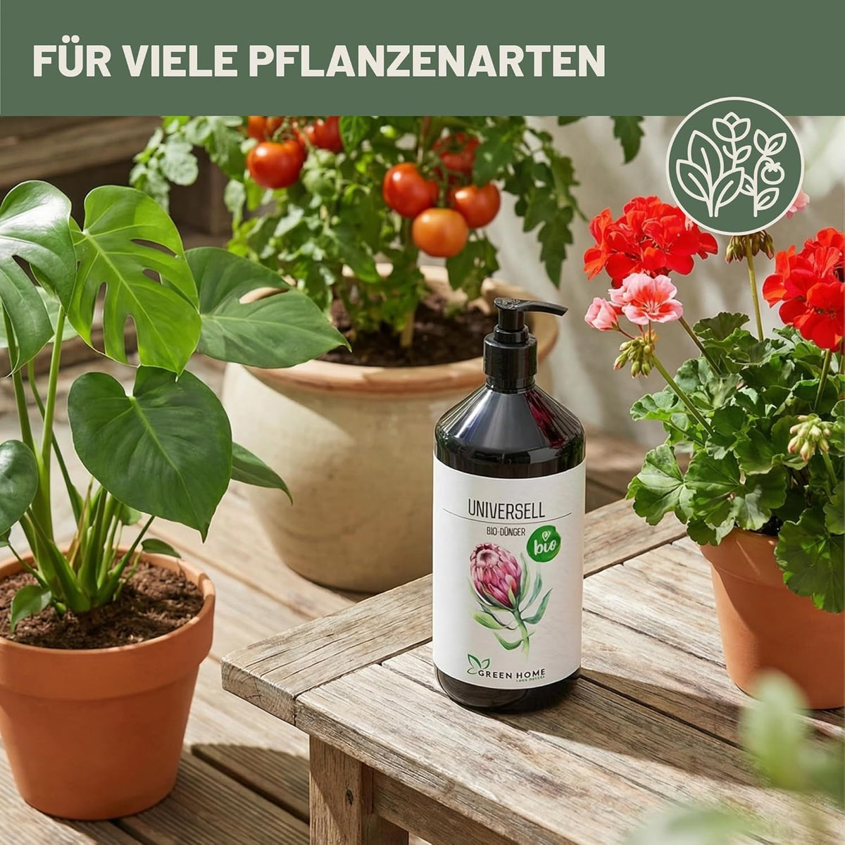 Green Home Bio Dünger Universell steht auf einem Holztisch zwischen verschiedenen Pflanzen wie Monstera, Tomaten und Geranien