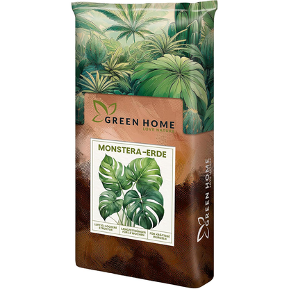 Green Home Monstera Erde Sack mit Monstera-Blatt-Motiv auf der Vorderseite vor tropischem Pflanzenhintergrund.