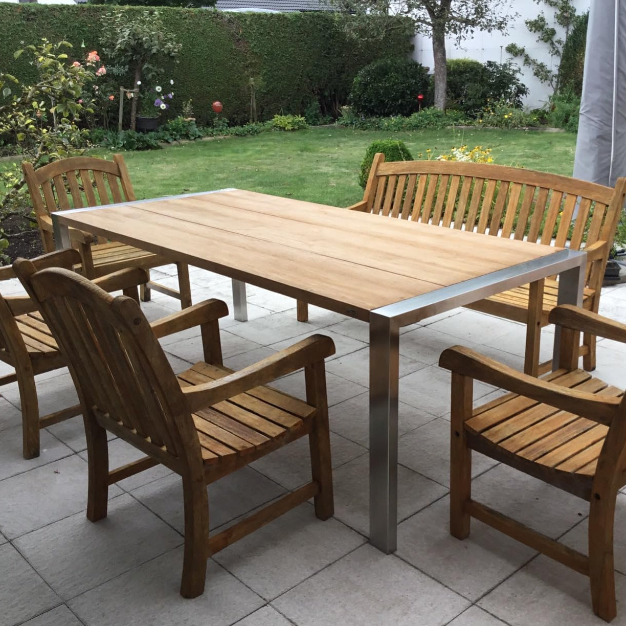Gartentisch und Stühle aus Holz auf einer Terrasse im Außenbereich