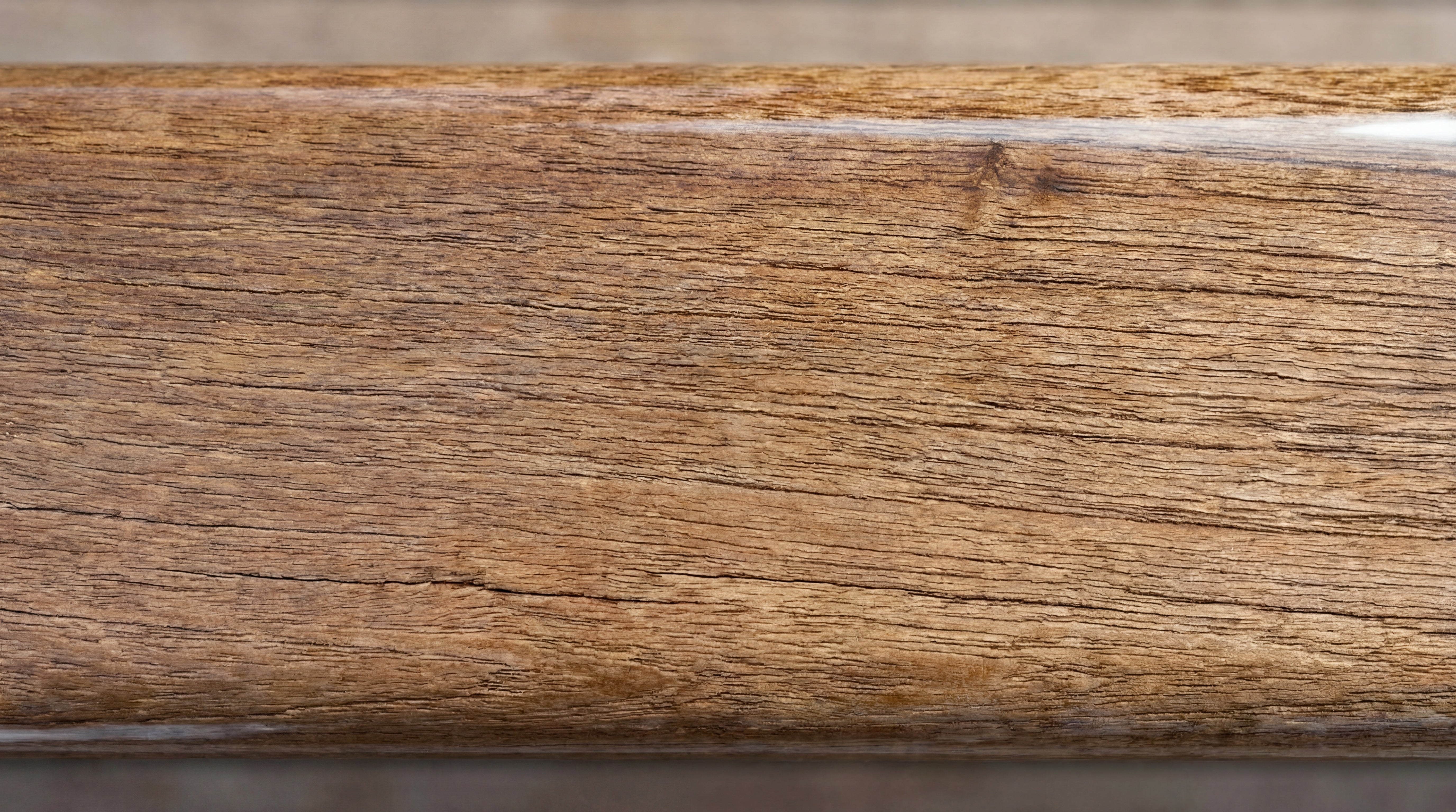 Detailaufnahme eines geoeelten Holzbretts mit dunklerer, betonter Maserung und leicht glaenzender Oberflaeche