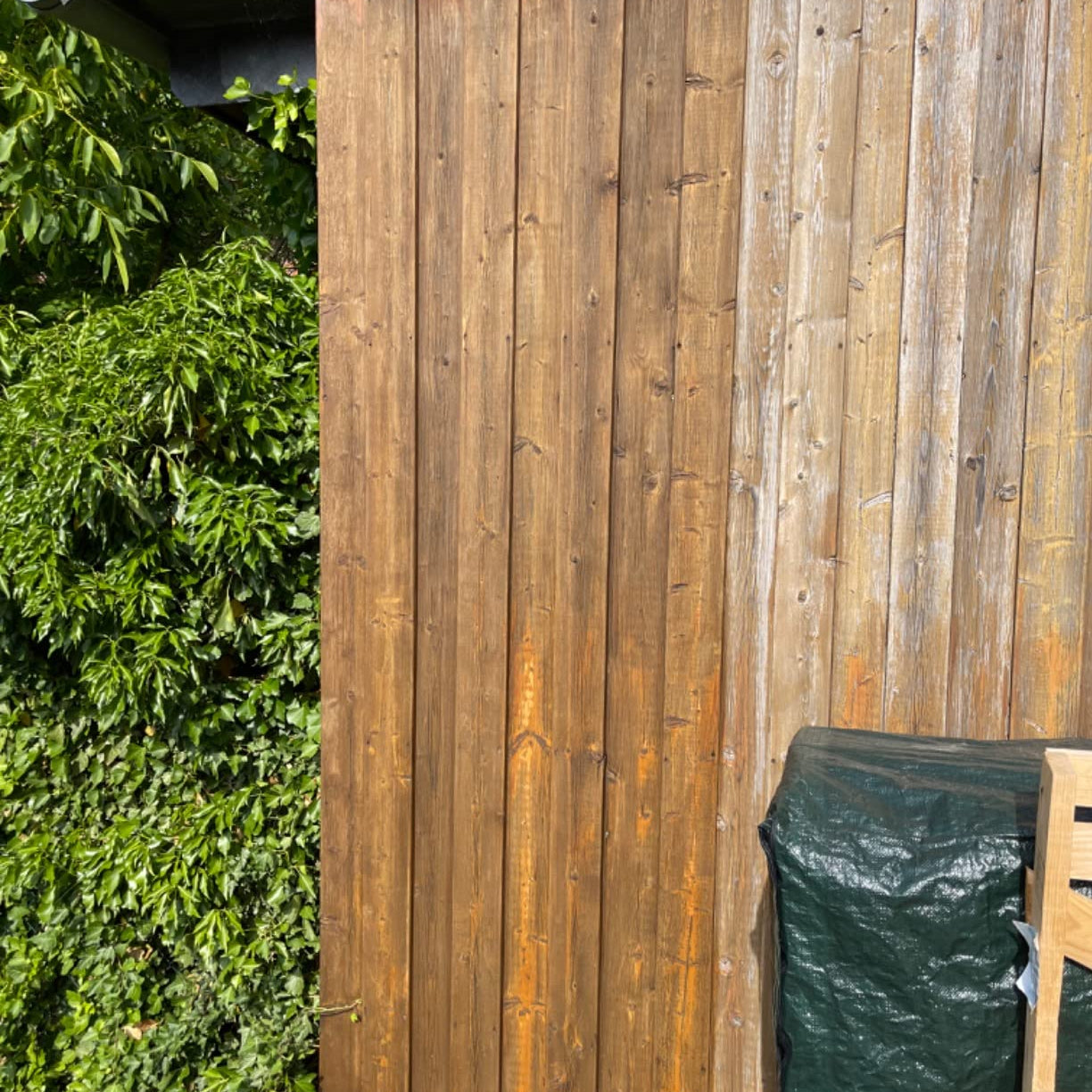 Vergleich einer Holzfassade im Außenbereich mit unterschiedlich behandelten und verwitterten Holzflächen nebeneinander.