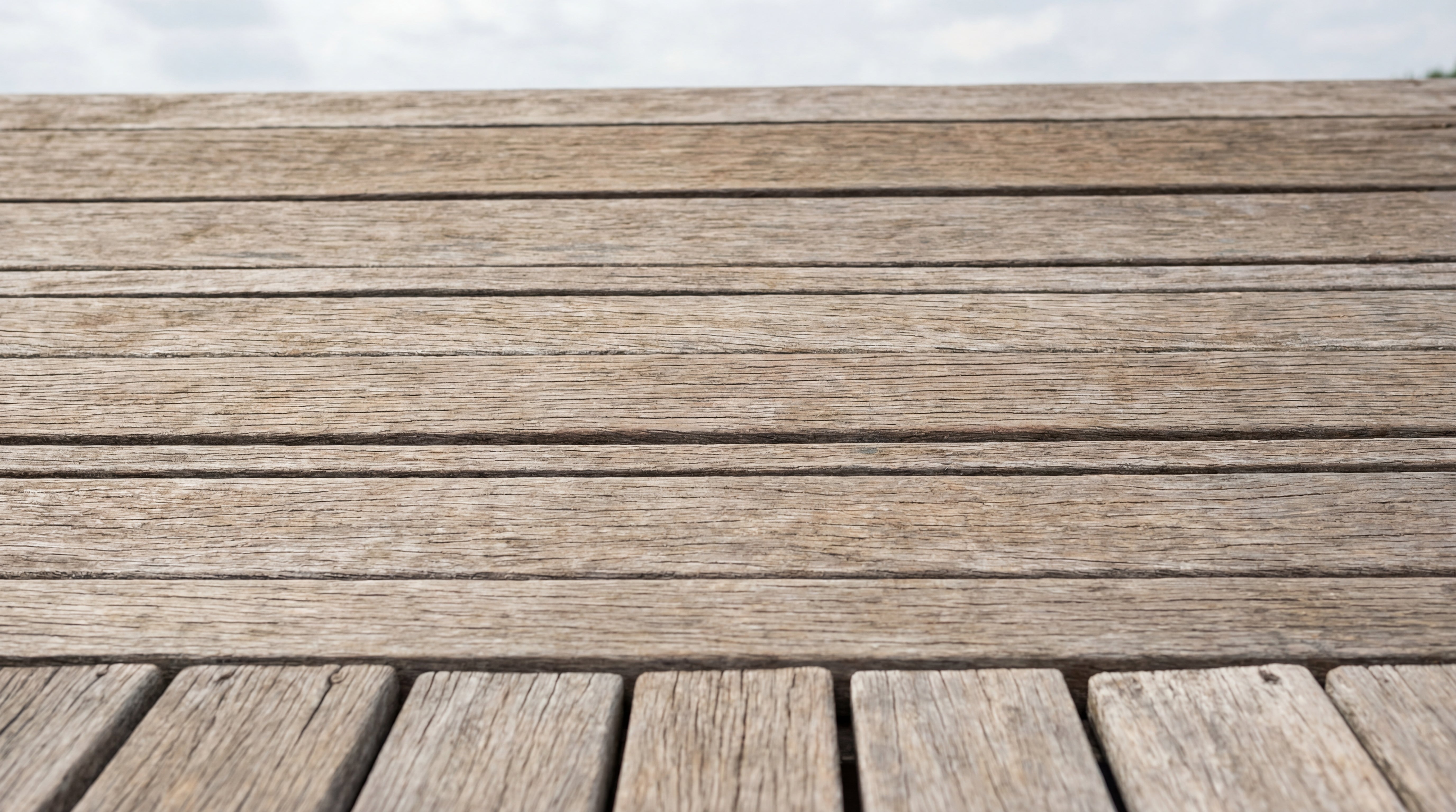 Vergraute und unbehandelte Holzterrasse mit sichtbaren Witterungsspuren