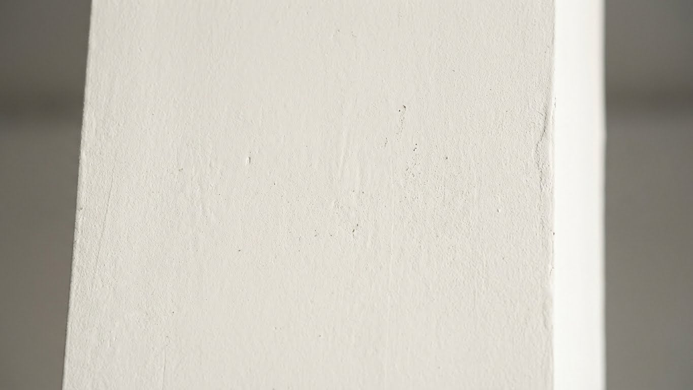Detailaufnahme einer weiss verputzten Innenwand mit feiner Struktur