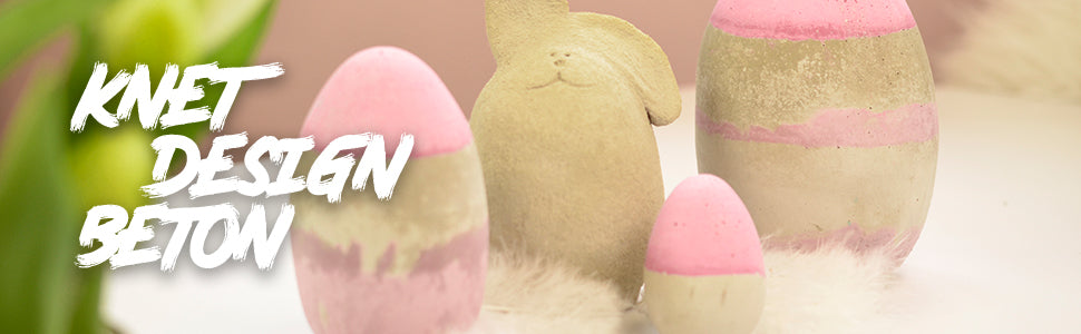 Osterliche Dekoration aus Knetbeton mit bemalten Eiern und Hasenfigur sowie Schriftzug Knet Design Beton im Hintergrund.