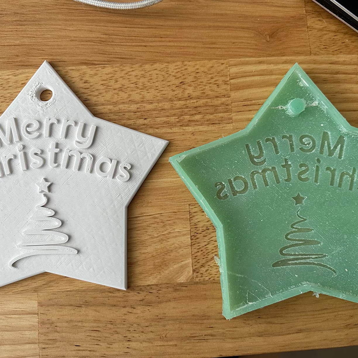 Mit LM Kreativ Abformsilikon flüssig 1 kg System Blau gefertigte Sternform mit Schriftzug Merry Christmas als Positiv und Negativ.