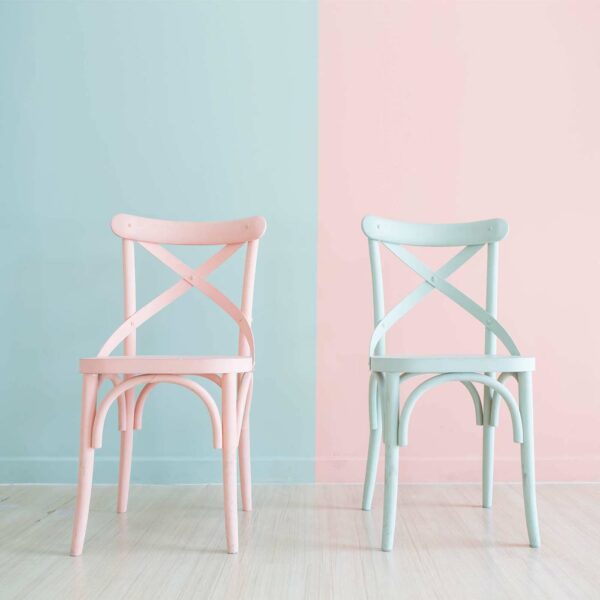 Zwei Holzstuehle in Pastell Rosa und Mint gestrichen mit LM Kreativ Chalky Moebelfarbe vor zweifarbigem Hintergrund in passenden Pastelltoenen.