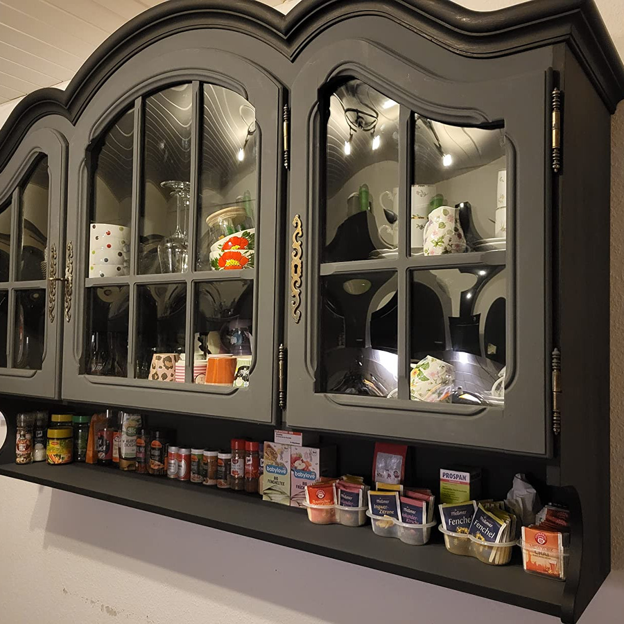 Vitrine im Landhausstil gestrichen mit LM Kreativ Chalky Moebelfarbe in Grau mit Glasfront und dekorativem Geschirr.