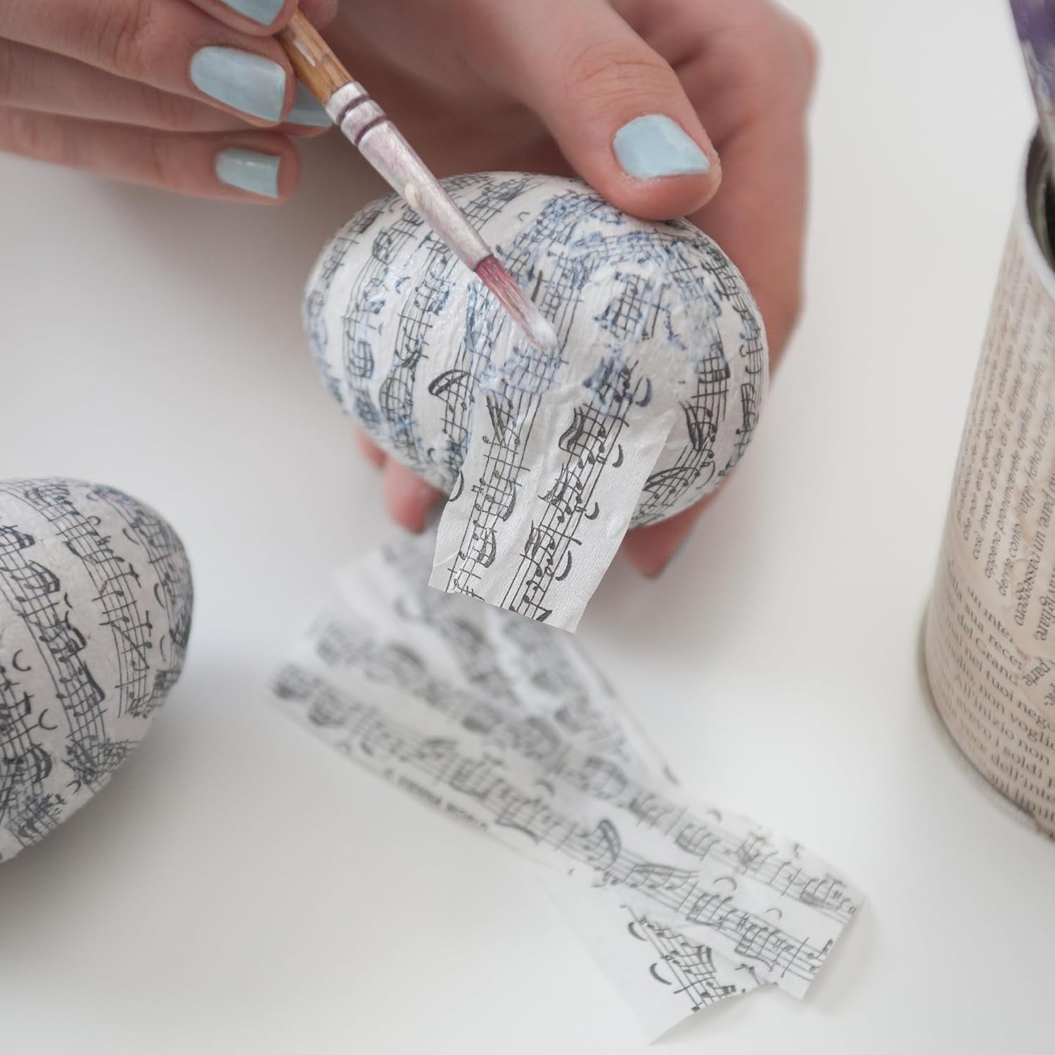 Aufbringen von Notenpapier auf ein Ei mit LM Kreativ Decoupage Kleber fuer Decoupage Technik