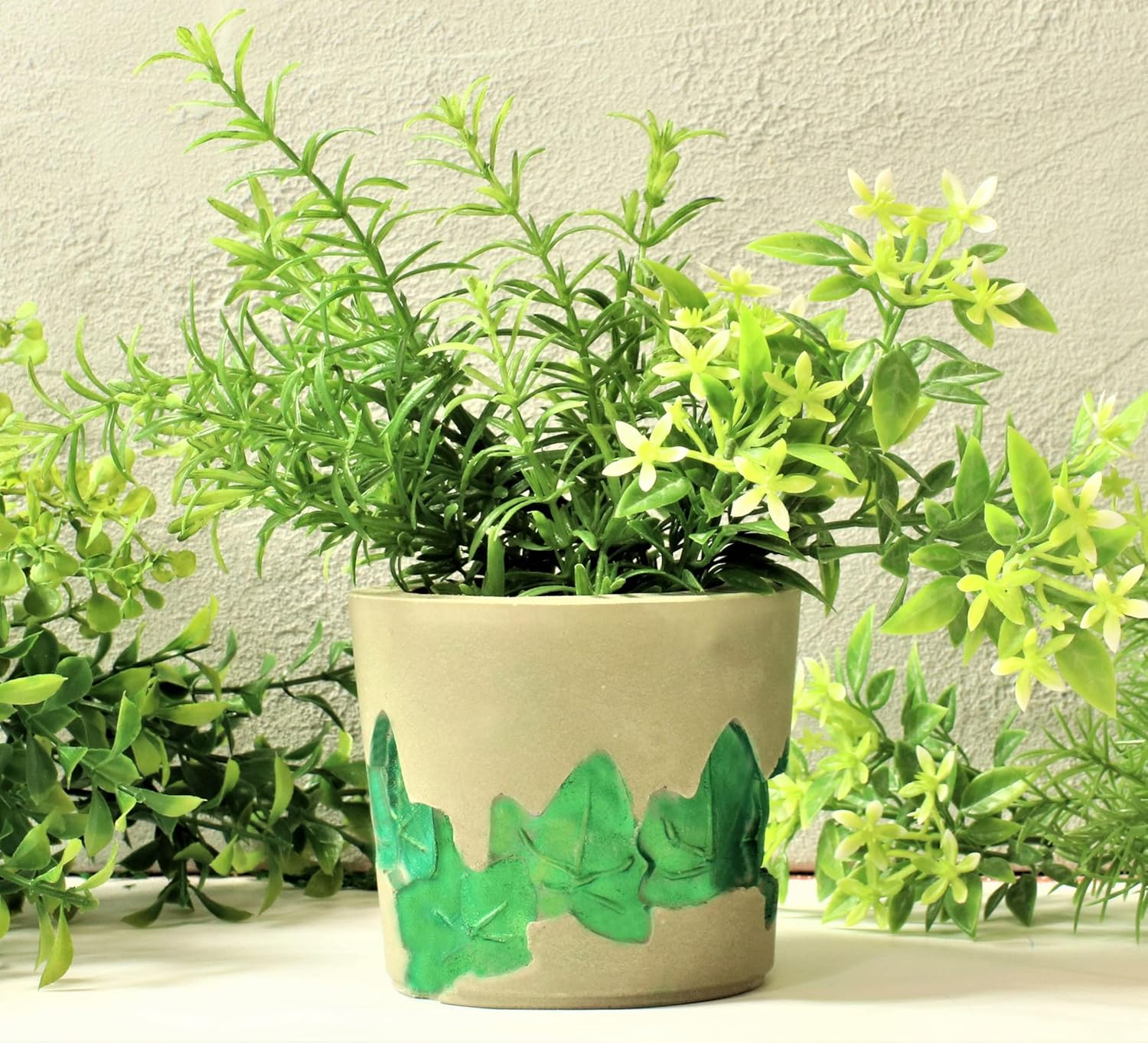 Mit LM Kreativ Design Beton Ultrafein Express gegossener Blumentopf mit grünem Efeu-Dekor.