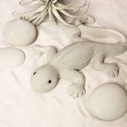 Detailreiche Eidechsenfigur aus LM Kreativ Design Beton Ultrafein Express auf sandigem Untergrund.