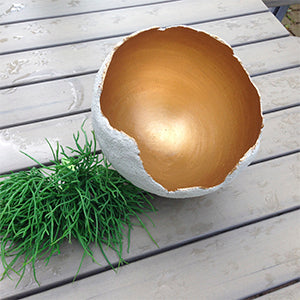 Halbrunde Schale aus LM Kreativ Design Beton Ultrafein Express mit goldfarbener Innenfläche auf Holztisch.