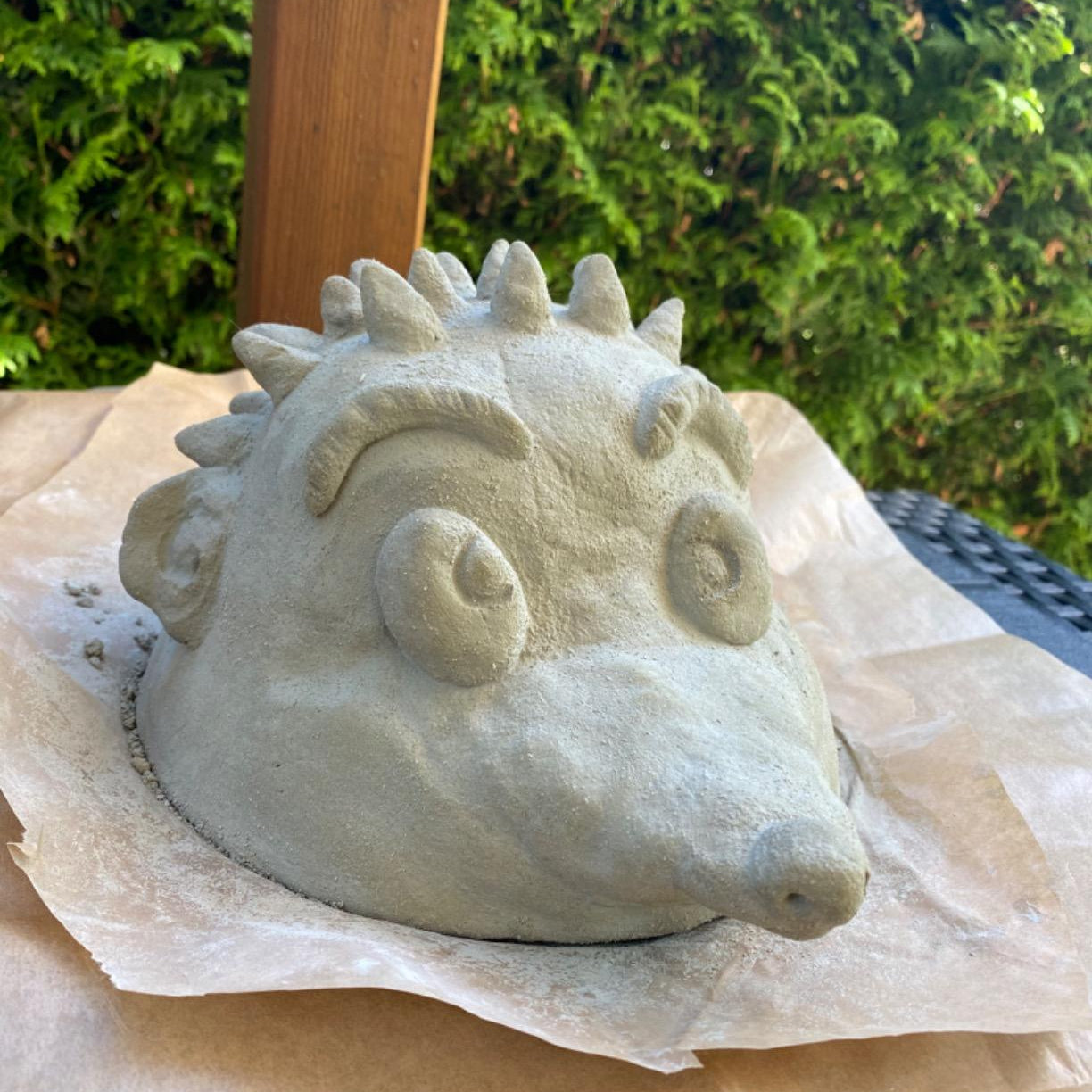 Mit LM Kreativ Knetbeton geformte Igel-Figur im unbehandelten Zustand auf Papierunterlage im Außenbereich.