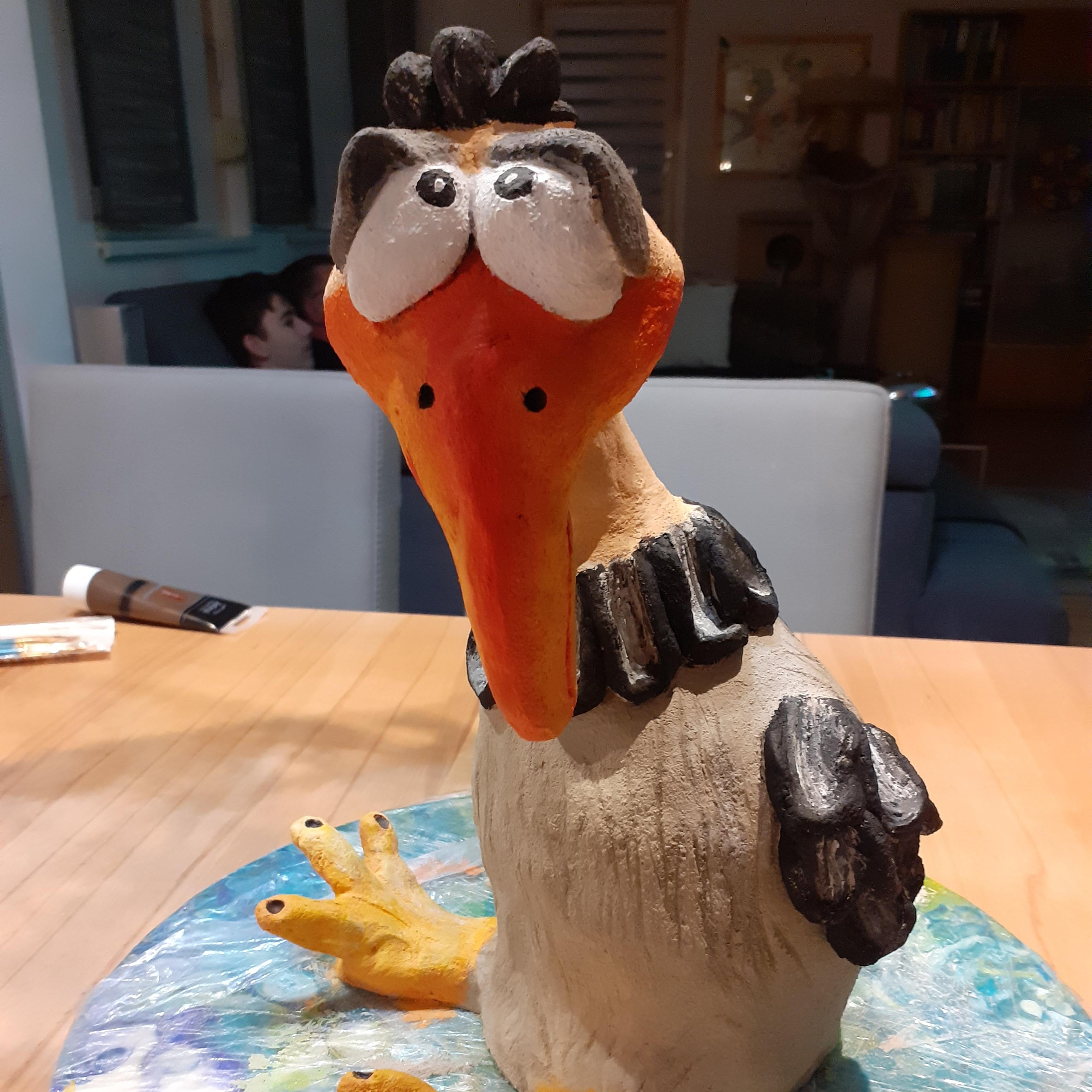 Mit LM Kreativ Knetbeton modellierte und bemalte Vogel-Figur mit großem Schnabel auf einem Tisch platziert.