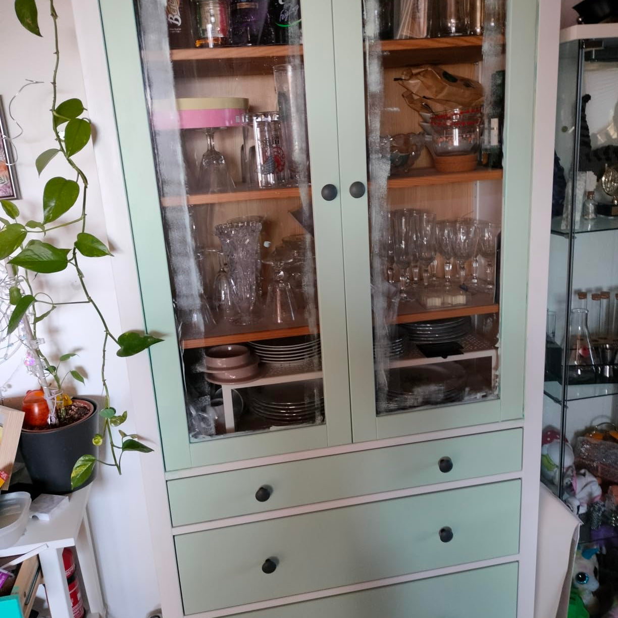 Vitrine mit Glasfront in Salbeigrün gestrichen mit LM Kreativ Möbelfarbe 500 ml, gefüllt mit Geschirr und Gläsern.