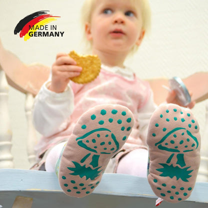 Baby mit Socken mit rutschfester Unterseite und Pilzmotiv, gestaltet mit der LM Kreativ Socken Stopper Textilfarbe, Hinweis auf Made in Germany.