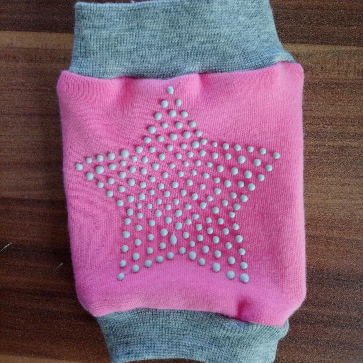 Rosa und grauer Knieschoner mit sternfoermig angeordneten rutschfesten Stopperpunkten aus LM Kreativ Socken Stopper Textilfarbe.