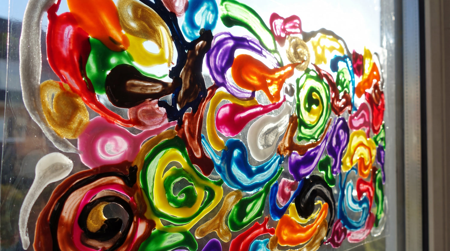 Nahaufnahme bunter Window Color Farbe auf transparenter Folie, glänzende Struktur und intensive Farbpigmente.