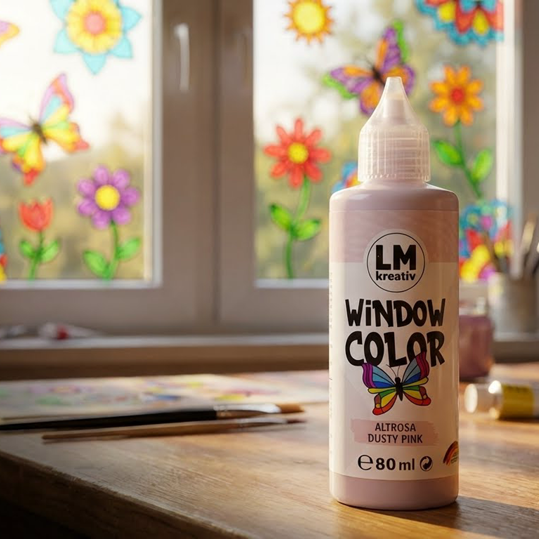 LM Kreativ Window Color in Altrosa Dusty Pink 80 ml steht auf einem Tisch vor einem Fenster mit bunten Blumen- und Schmetterlingsmotiven aus Fenstermalfarbe.