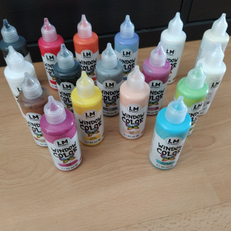 Mehrere LM Kreativ Window Color Farbflaschen in verschiedenen Farben auf einem Tisch angeordnet