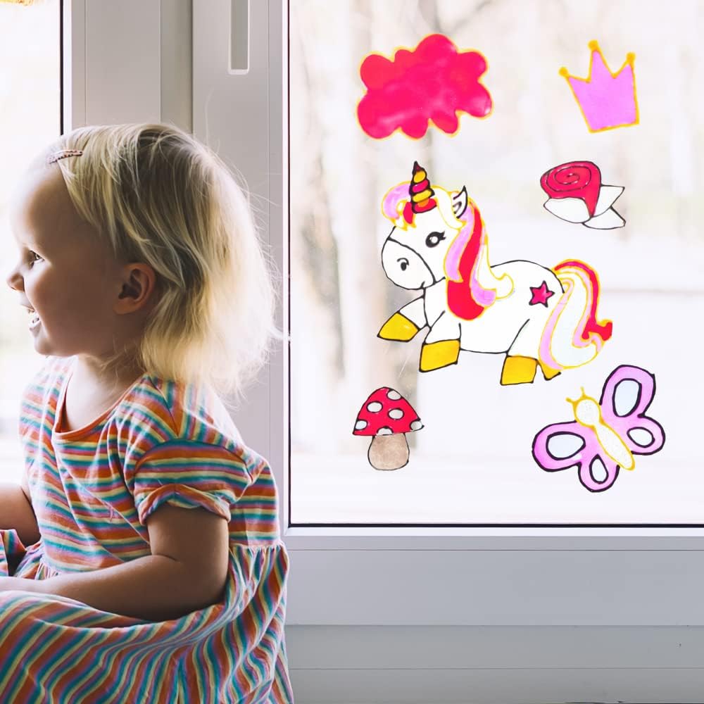 Kind betrachtet selbst gestaltete Einhornmotive am Fenster mit dem LM Kreativ Window Color.