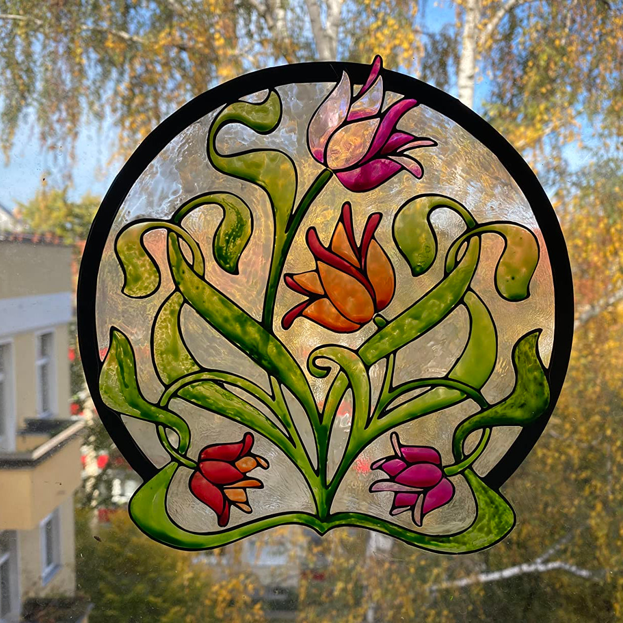 Rundes Blumenmotiv als Fensterbild gestaltet mit dem LM Kreativ Window Color Set Kleine Entdecker in Gruen, Pink und Orange.