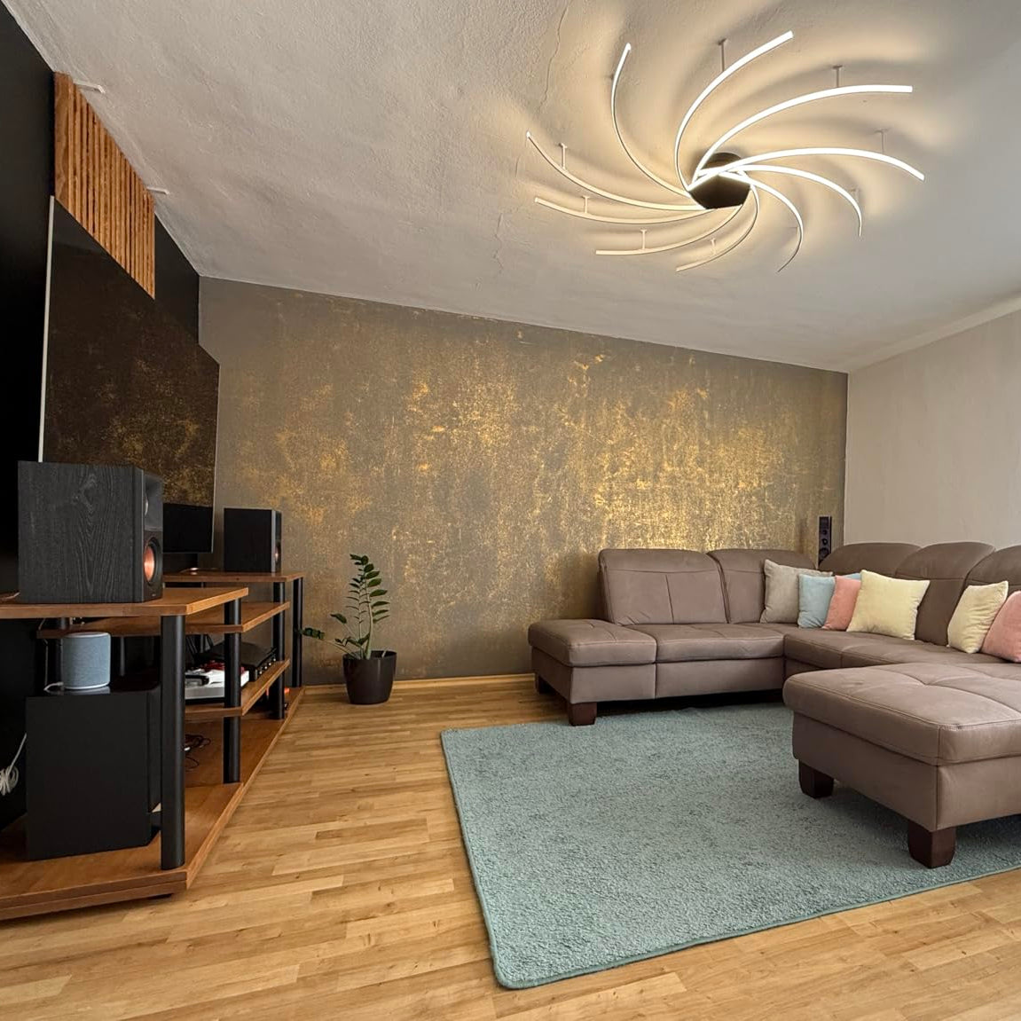 Luxuriöse Gold-Akzentwand im Wohnzimmer – intensiver Metallic-Schimmer je nach Lichteinfall.