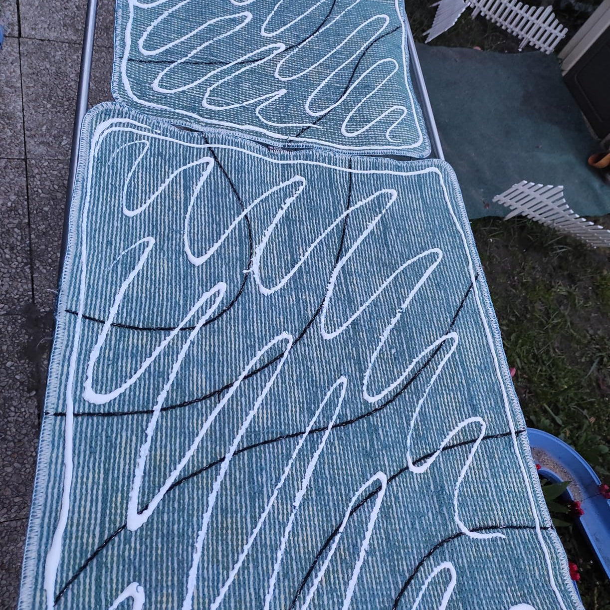 My Color Room Teppich Stopp Transparent in weißen Wellenlinien auf die Rückseite eines grünen Teppichs aufgetragen.