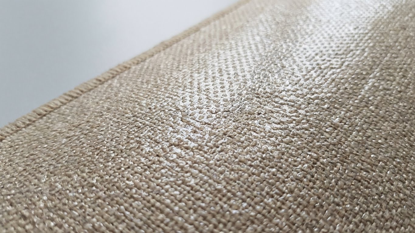 Nahaufnahme der transparenten, strukturierten Beschichtung von My Color Room Teppich Stopp auf der Teppichunterseite.