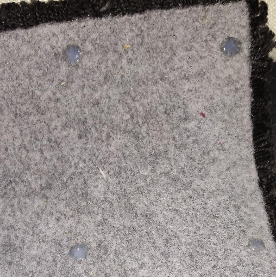 Punktueller Auftrag von My Color Room Teppich Stopp Transparent als rutschhemmende Noppen auf grauer Teppichrückseite.