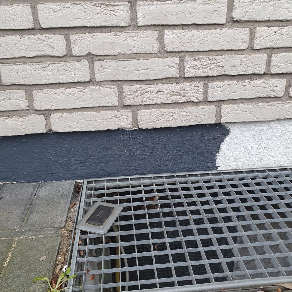 Teilweise gestrichener Sockelbereich zeigt den Farbauftrag der My Paint Sockel- und Dachfarbe im Vergleich zum Untergrund