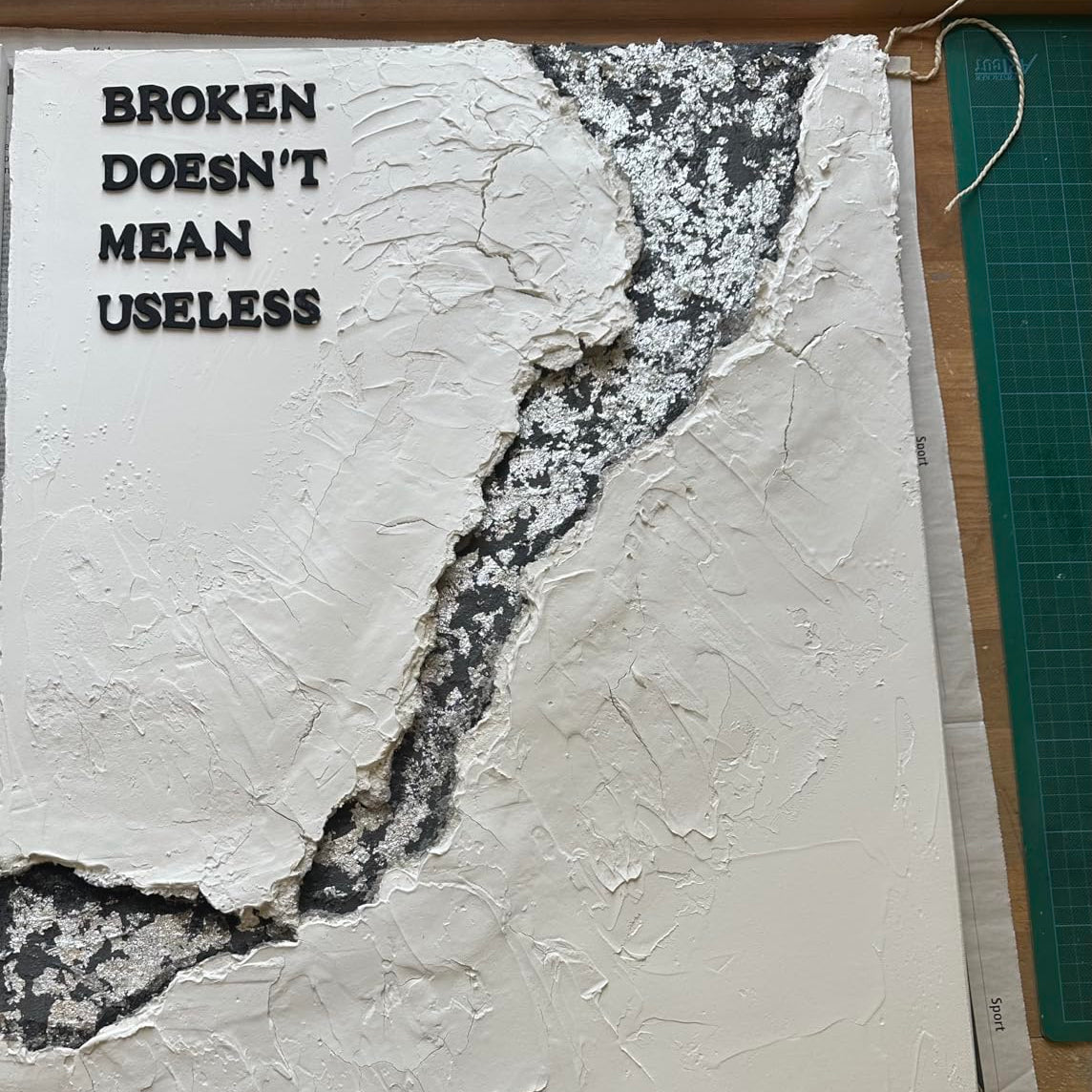 Relief-Kunstwerk mit Strukturpaste in Rissoptik und plastischer Oberfläche auf Leinwand.