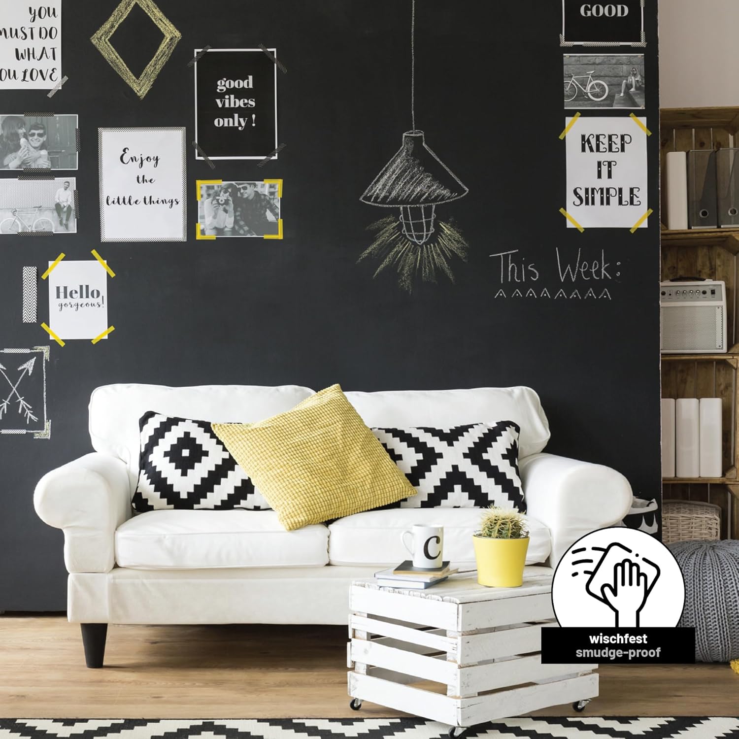 Schwarz gestrichene Tafelflaeche im Wohnzimmer mit Kreidezeichnungen und Zitaten hinter einem Sofa