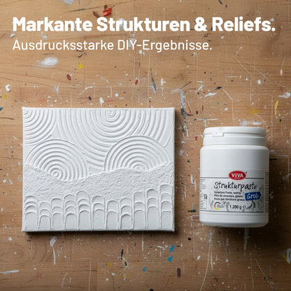 Mit Viva Decor Strukturpaste Grob gestaltete Leinwand mit ausgeprägten Reliefstrukturen neben dem Produktbehälter im Atelier.